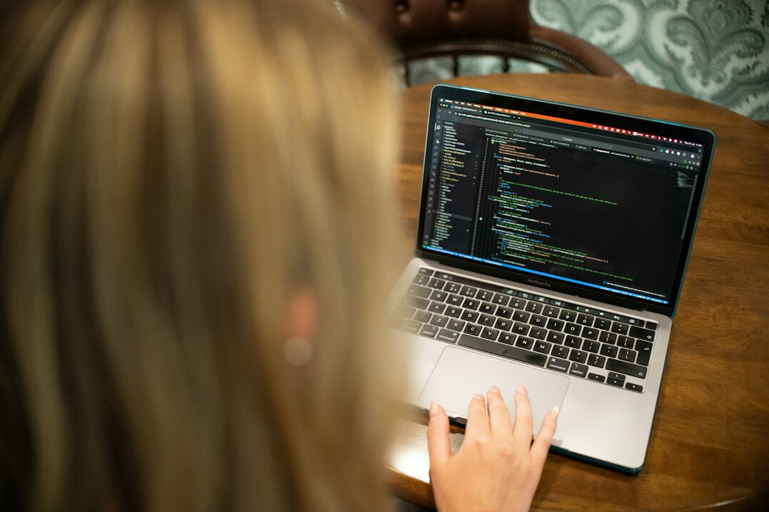 programmer writing code on laptop