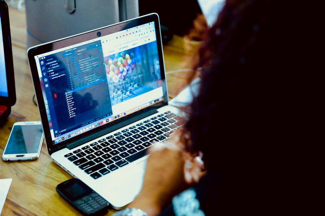 person coding on laptop at desk